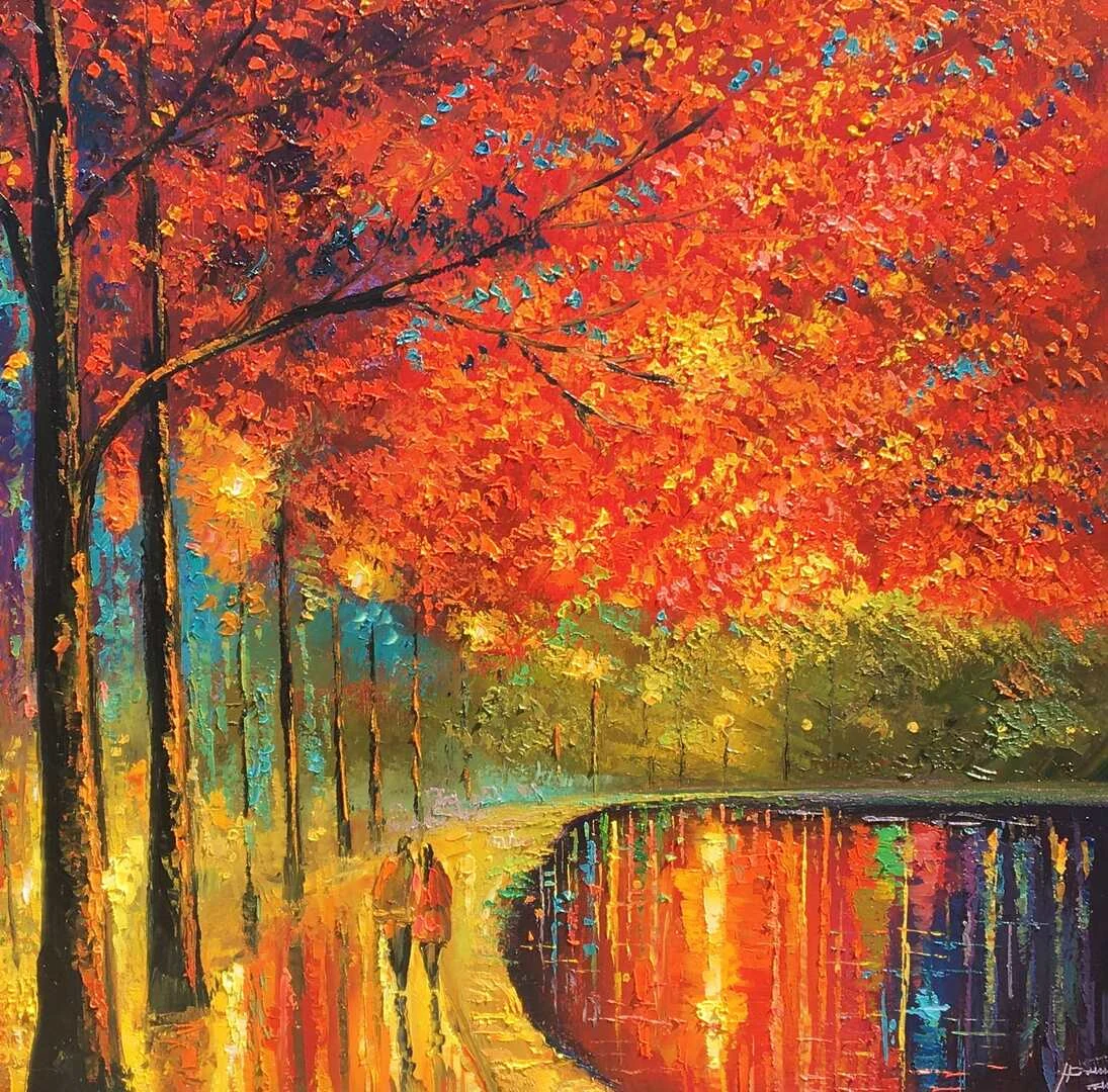 Paseantes bajo árboles rojos junto al reflejo de las luces nocturnas